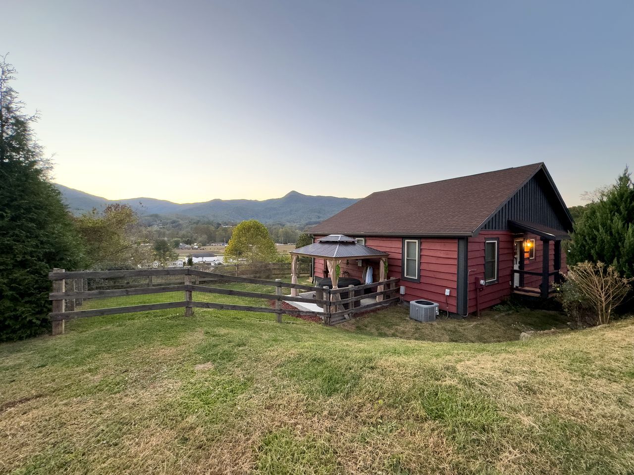 A red house with a porch and a covered outdoor seating area.