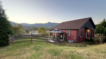 Ein rotes Haus mit Veranda und überdachter Außenlounge.