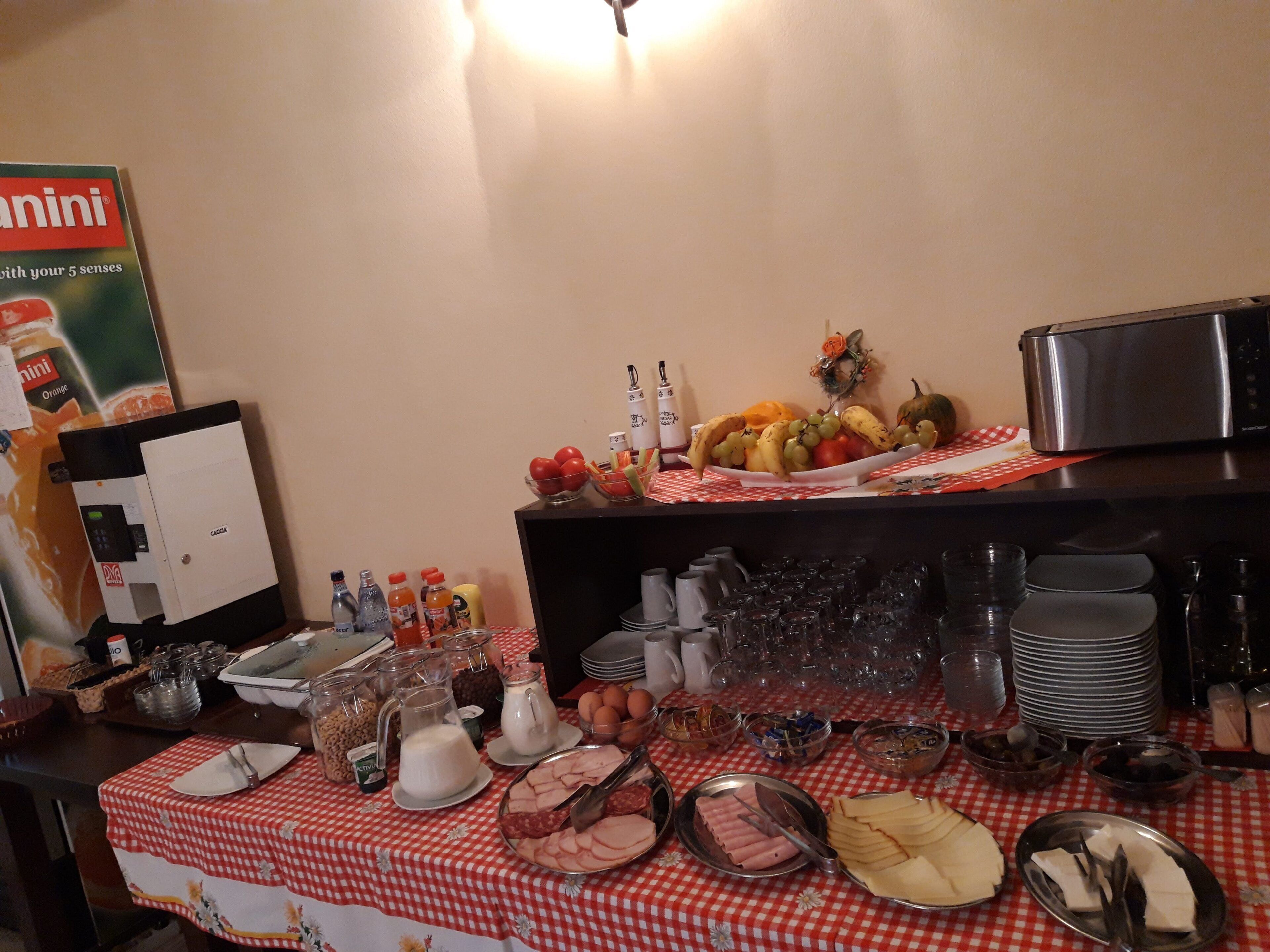 A buffet setup with various food items, beverages, and a microwave.