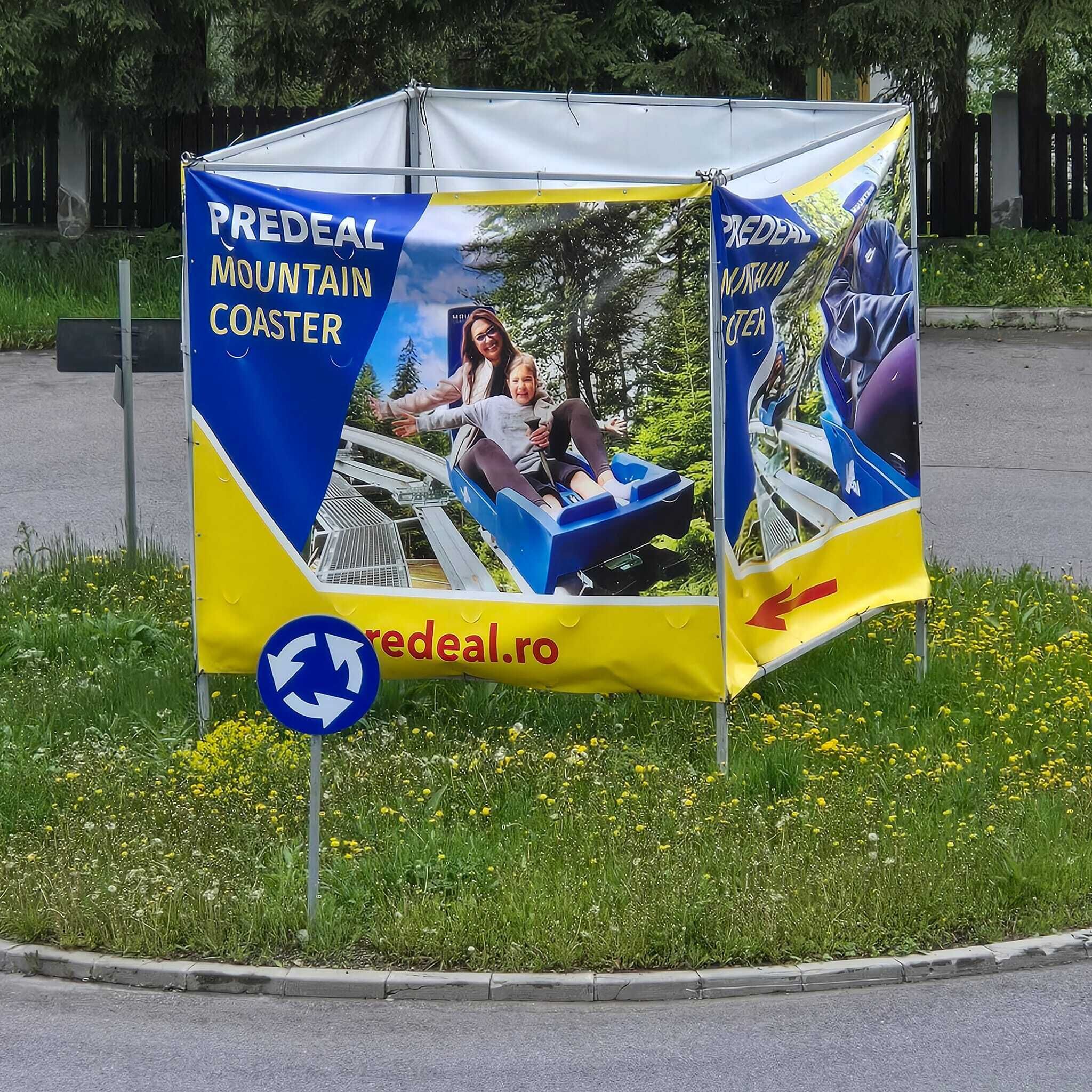 A promotional booth for the Predel Mountain Coaster with a website URL and a directional arrow.