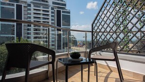 A balcony with two chairs, a small table, and a potted plant. - ORAK - Minimalist Aparthotel with Gym & Pool in Lavington (Nairobi)