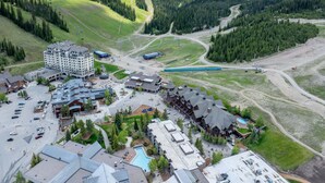 A ski resort with a large building, parking area, and a pool. - New Listing! Ski In/Out + Pool + Hot Tub at Lift House (Big Sky)