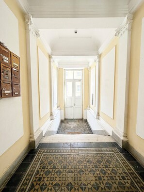 A hallway with a patterned floor, white walls, and a double door at the end. - Unique family home next to fortress + free parking (Petrovaradin)
