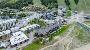 A resort with multiple lodging options, including cabins and hotels, set in a mountainous area with ski slopes. - New! Village Center Ski-In/Ski-Out 3-bed Suite! (Big Sky)