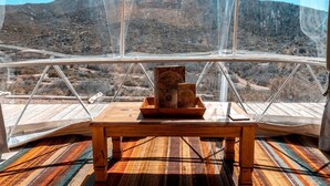 Ein Zimmer mit freiem Blick auf eine gebirgige Landschaft durch ein großes Fenster.