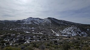 A mountainous landscape with sparse vegetation and snow patches. - Tranquil Desert Retreat in a Geodesic Dome with Scenic Views in Las Vegas, Nevada (Las Vegas)