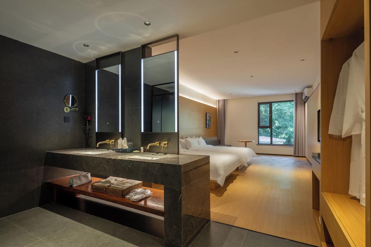 Une salle de bain moderne dotée d’un grand miroir, de deux vasques et d’un meuble-lavabo avec espace de rangement.