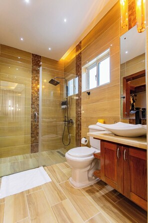 A modern bathroom with a glass-enclosed shower, a toilet, and a sink with a mirror above. - Luxurious 3-bedroom Apartment With Private Balcony in Puerto Plata (Puerto Plata)