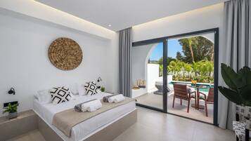 Un dormitorio moderno con una cama grande, una obra de arte circular en la pared y vistas a un patio exterior con piscina y sillas.