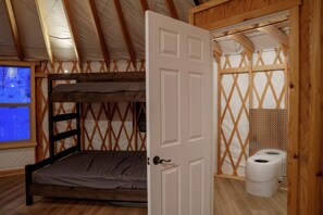A room with a bunk bed, a wooden door, a window with a view, and a toilet. - Stunning Full Equipped Yurt with Sauna in Boise, Idaho (Boise)