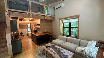 A loft-style room with a kitchen, dining area, and a large window.