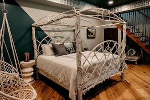 A bed with a white canopy, a hanging chair, and a staircase in the background. - Incredible Secluded Barn with Hot-tub and Petting Zoo in Sugar Grove, North Carolina (Sugar Grove)