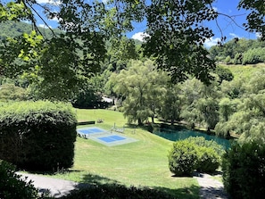 A tennis court surrounded by lush greenery and a small pond. - Incredible Secluded Barn with Hot-tub and Petting Zoo in Sugar Grove, North Carolina (Sugar Grove)