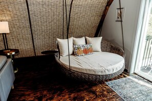A cozy room with a circular bed, a small table, a lamp, and a view of the outdoors. - Incredible Secluded Barn with Hot-tub and Petting Zoo in Sugar Grove, North Carolina (Sugar Grove)