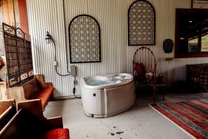 A room with a hot tub, a wooden bench, a red chair, and a patterned wall. - Incredible Secluded Barn with Hot-tub and Petting Zoo in Sugar Grove, North Carolina (Sugar Grove)