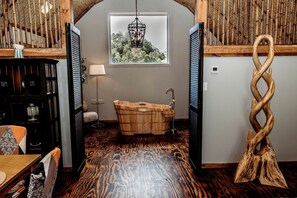 A room with a wooden bathtub, a wooden sculpture, and a window with a view of trees. - Incredible Secluded Barn with Hot-tub and Petting Zoo in Sugar Grove, North Carolina (Sugar Grove)