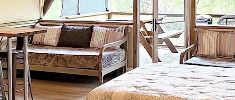 Una habitación con carpa, una cama, una mesa y una silla.