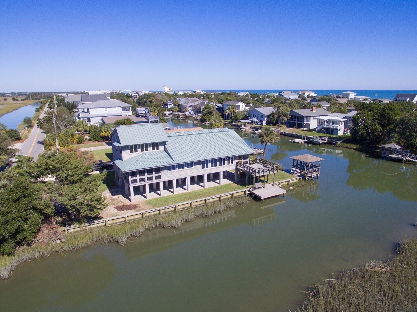 A waterfront property with a large house, dock, and boats.
