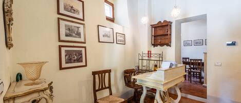 Um quarto com uma mesa de jantar, cadeiras, um candelabro e quadros nas paredes.