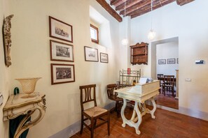 A room with a dining table, chairs, a chandelier, and framed pictures on the wall. - Locanda di Montisi Contrada Room among the Hills of Montalcino (Montisi)