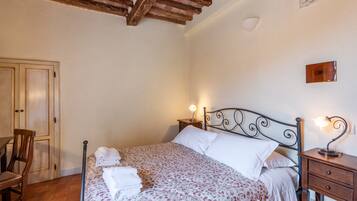 Une chambre à coucher avec un lit, des tables de chevet, une chaise et un plafond en bois.
