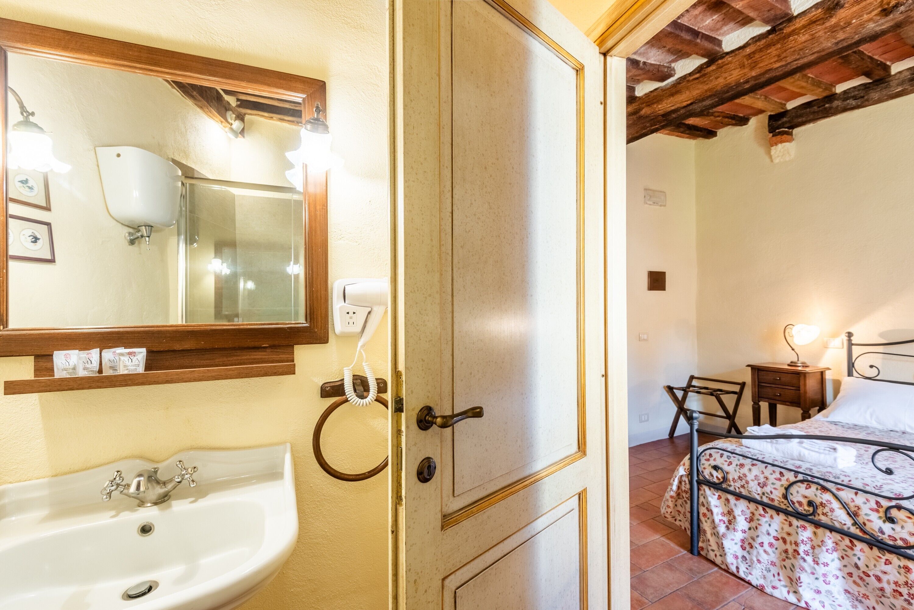 A bathroom with a sink, mirror, and towel rack.