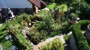 A garden with a variety of plants, a small pond, and a rustic building. - Holiday Apartment for 10 People (145 m²) in Königsfeld (Königsfeld)