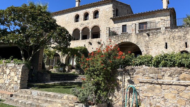 A stone building with arched windows and a balcony. - At the foot of the Pyrenees (Maçanet de Cabrenys)