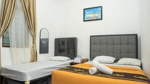 A hotel room with two beds, a TV, a mirror, and a framed picture on the wall.
