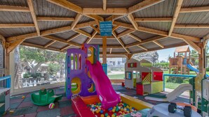 Ein Spielbereich für Kinder mit Rutsche, Bällebad und verschiedenen Spielgeräten.