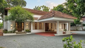 A two-story house with a tiled roof, a covered porch, and a gravel driveway. - Vayal Varam Private Villa Peaceful Nature Stay Kollam (Kollam)
