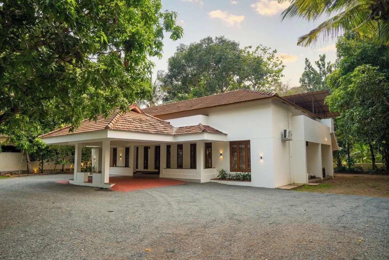 A two-story house with a covered patio, surrounded by trees.