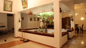 A modern interior with a central island, a hanging lamp, and a potted plant. - Vayal Varam Private Villa Peaceful Nature Stay Kollam (Kollam)