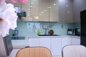 Apartamento superior, 2 quartos, sacada, vista para o jardim | Cozinha privada | Geladeira, micro-ondas, cooktop, talheres/pratos/utensílios de cozinha