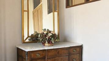 Un mobile bagno in legno con uno specchio e un vaso di fiori.