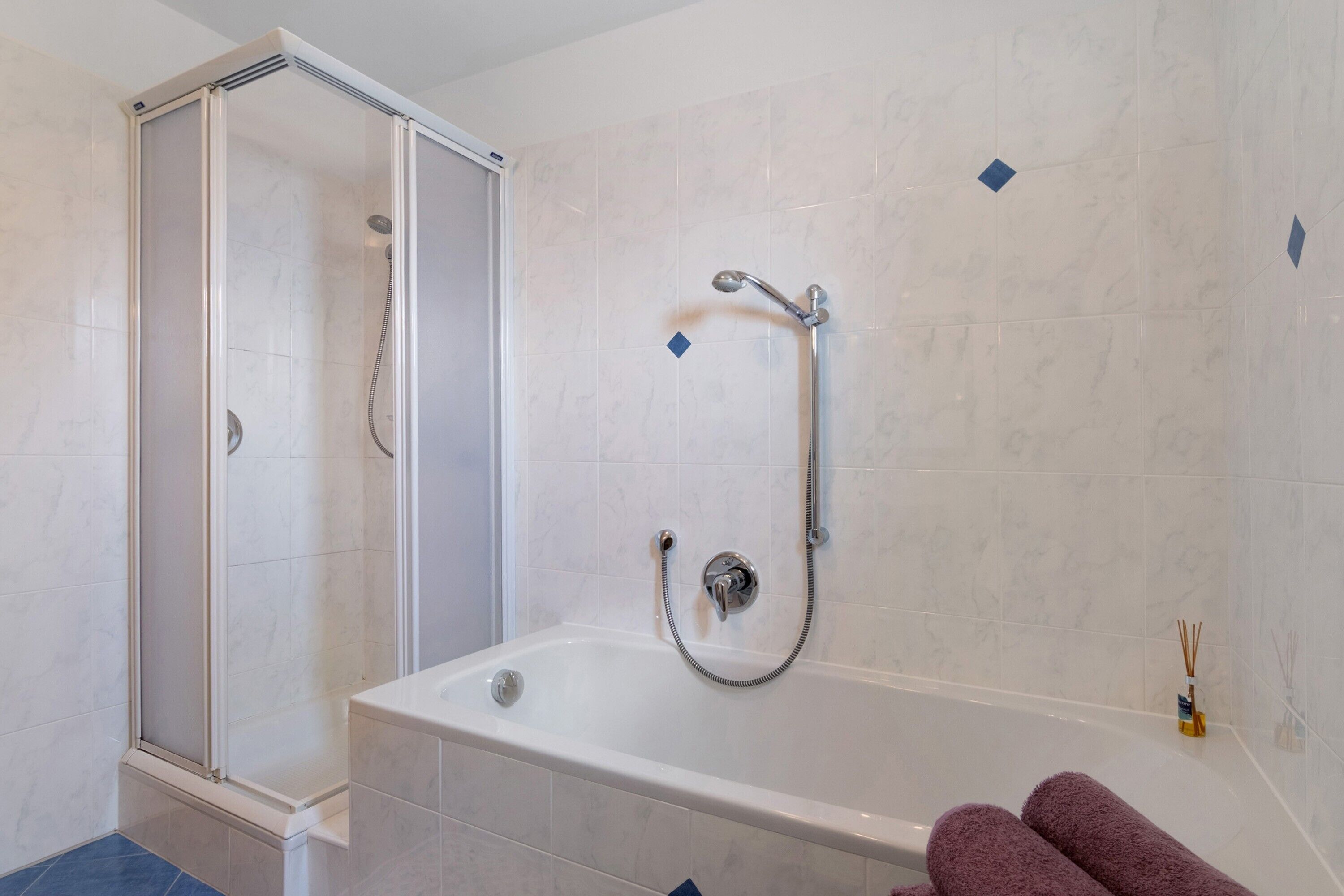 Un bagno con cabina doccia, vasca da bagno e soffione.