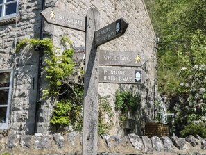 Ein hölzernes Wegweiser mit Richtungspfeilen zu Woo Dale, Chee Dale und dem Pennine Bridleway.