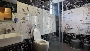 Ein Badezimmer mit einem weißen Waschbecken, einer Toilette und einer Duschkabine aus Glas.
