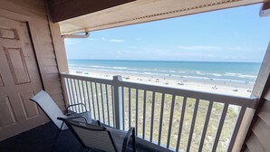 A balcony with a view of the beach, a door, and two chairs. - 10% off 3-7 nights through Dec. 1BR 1BA OF condo. Outdoor pool. Cozy getaway. (North Myrtle Beach)