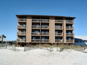 Ein mehrstöckiges Hotel mit Balkonen in Strandnähe.