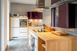 Eine moderne Küche mit Einbauofen, Mikrowelle und Spüle aus Edelstahl.