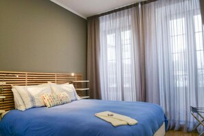 Ein Schlafzimmer mit Bett, Vorhängen und einem Fenster.
