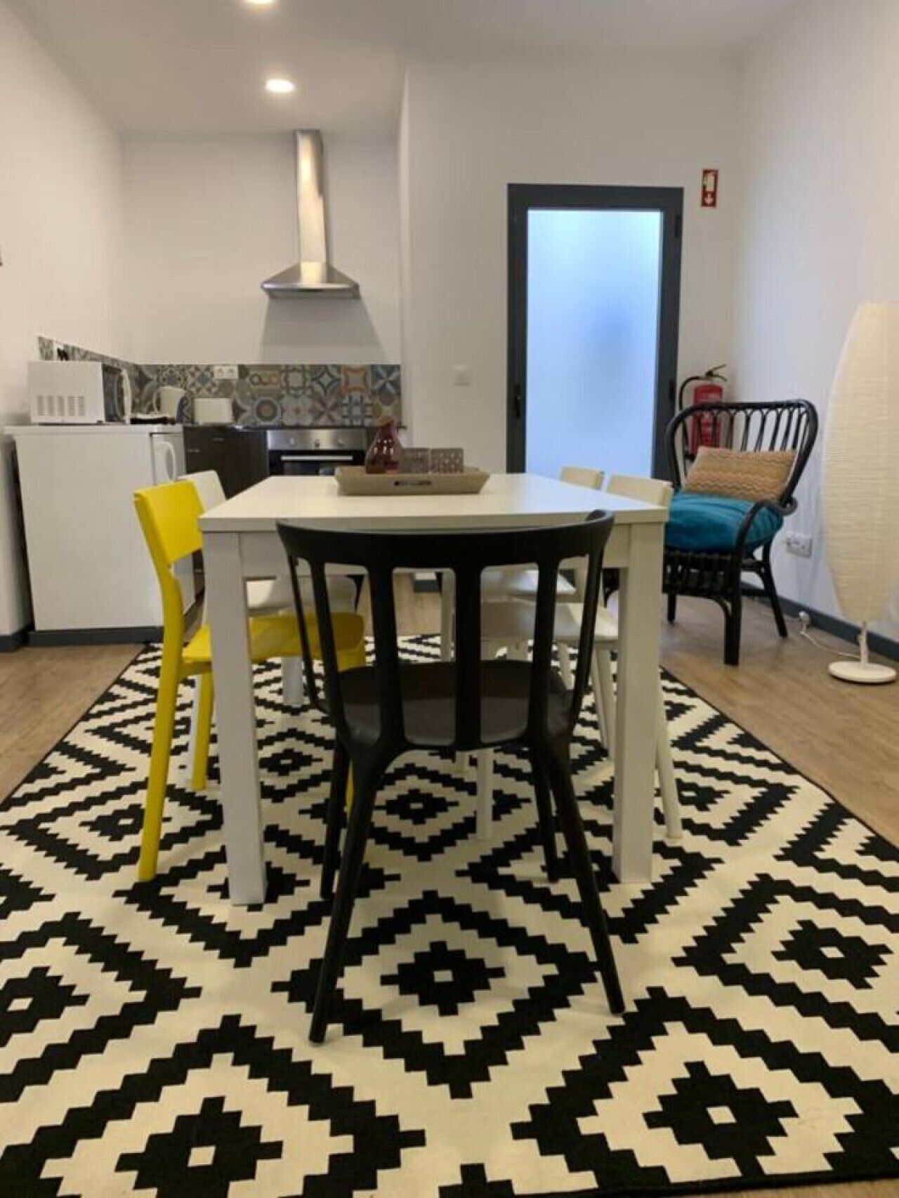 Ein Essbereich mit Tisch, Stühlen und einem gemusterten Teppich.