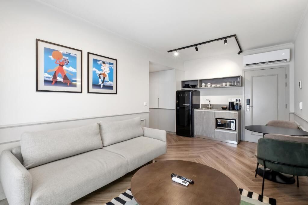 Un salon moderne avec un canapé, une table basse et un coin cuisine à l’arrière-plan.
