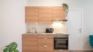 Una cocina moderna con armarios de madera, horno empotrado y cafetera.