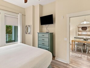 Ein Schlafzimmer mit Bett, Kommode, Fernseher und einer Essecke mit Tisch und Stühlen.