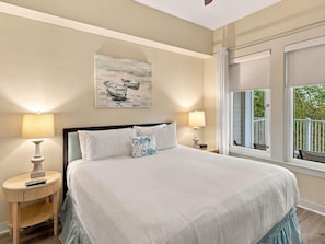 A bedroom with a bed, two bedside tables, a painting, and a window with a view. - One Bedroom Condo at Bahia in Sandestin Golf and Beach Resort (Miramar Beach)