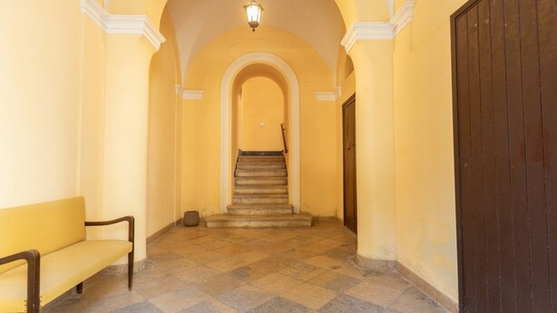 Ein Flur mit einer Bank, einer Treppe und einer Tür.