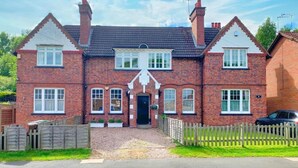 A two-story brick house with a symmetrical facade, a central entrance, and a picket fence. - Apartment Sleeps 4 With Enclosed Garden (Birmingham)
