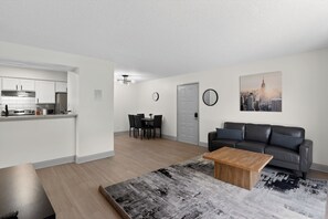 Eine moderne Wohnung mit Küche, Essbereich, Wohnzimmer und einem Stadtbild-Gemälde.